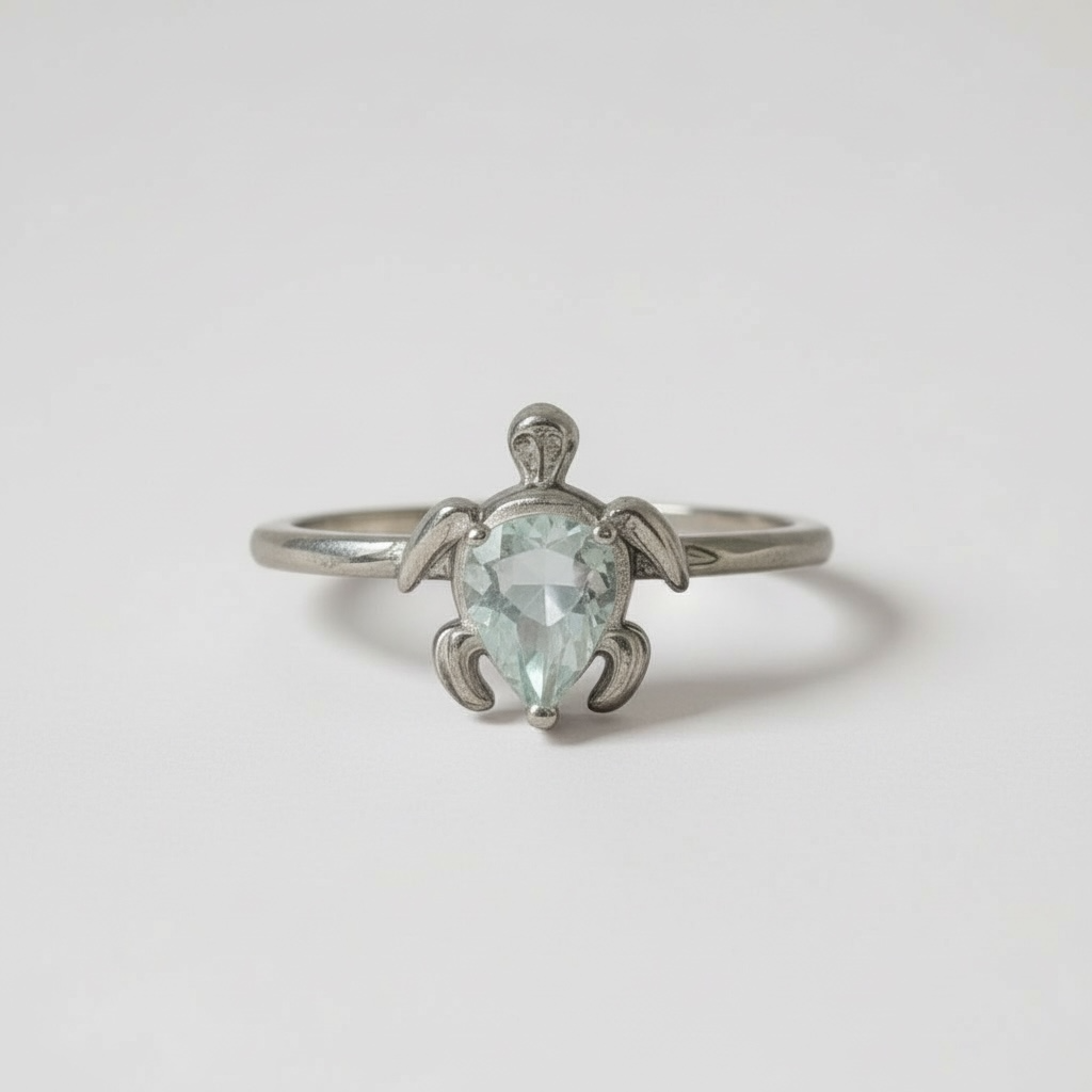 Sterling silver turtle ring with a faceted teardrop aquamarine. Sizes 5–10. Gentle, calming, and symbolic.