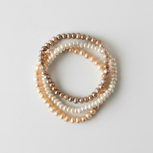 Set of three natural freshwater pearl bracelets with irregular 3–5 mm beads. Cream, champagne, and mocha tones for soft, timeless elegance.